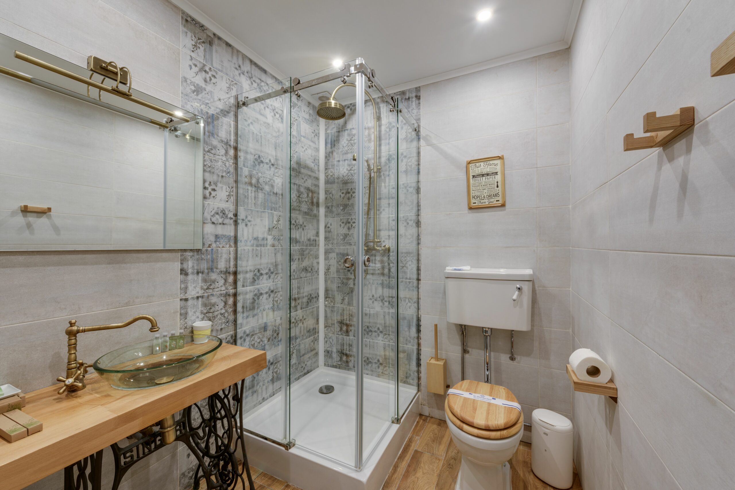 Stylish bathroom featuring a glass shower, wooden sink and toilet seat, and modern decor.